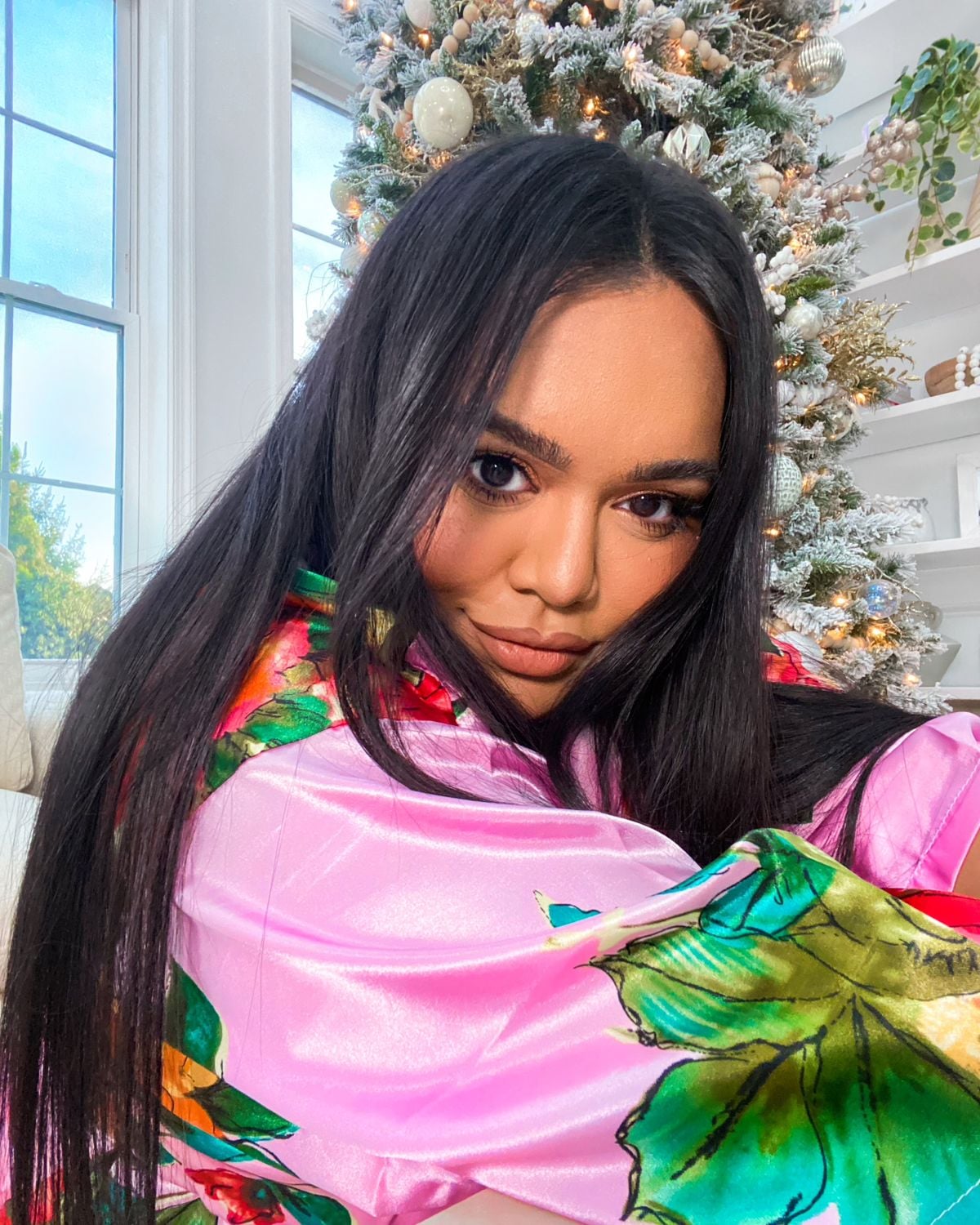 Nabela Noor sitting in front of Christmas tree