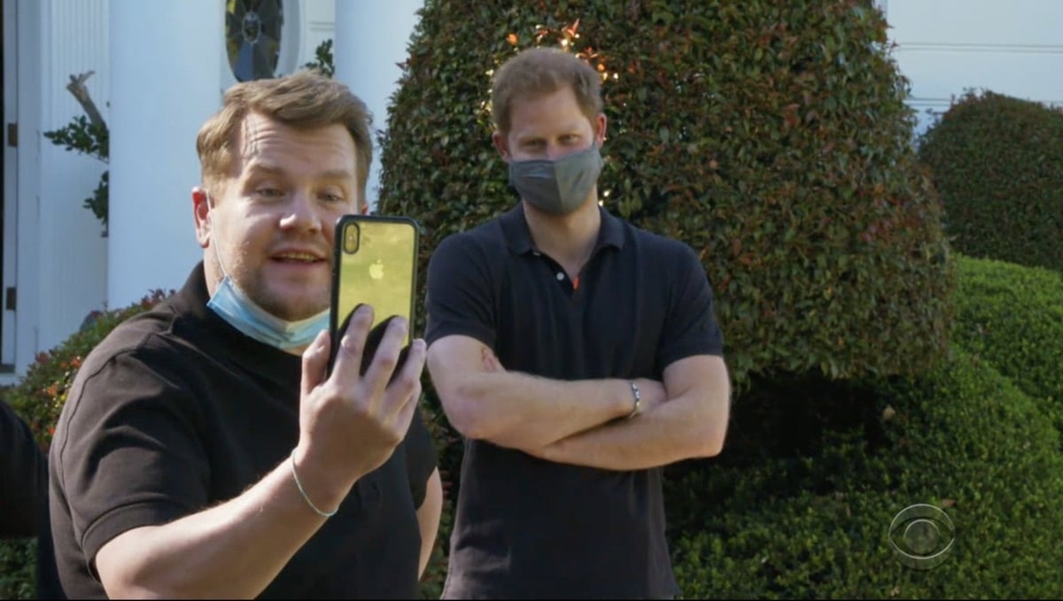 James Corden holds up a phone while he and Prince Harry are on a video call in this still from the new Prince Harry James Corden Interview