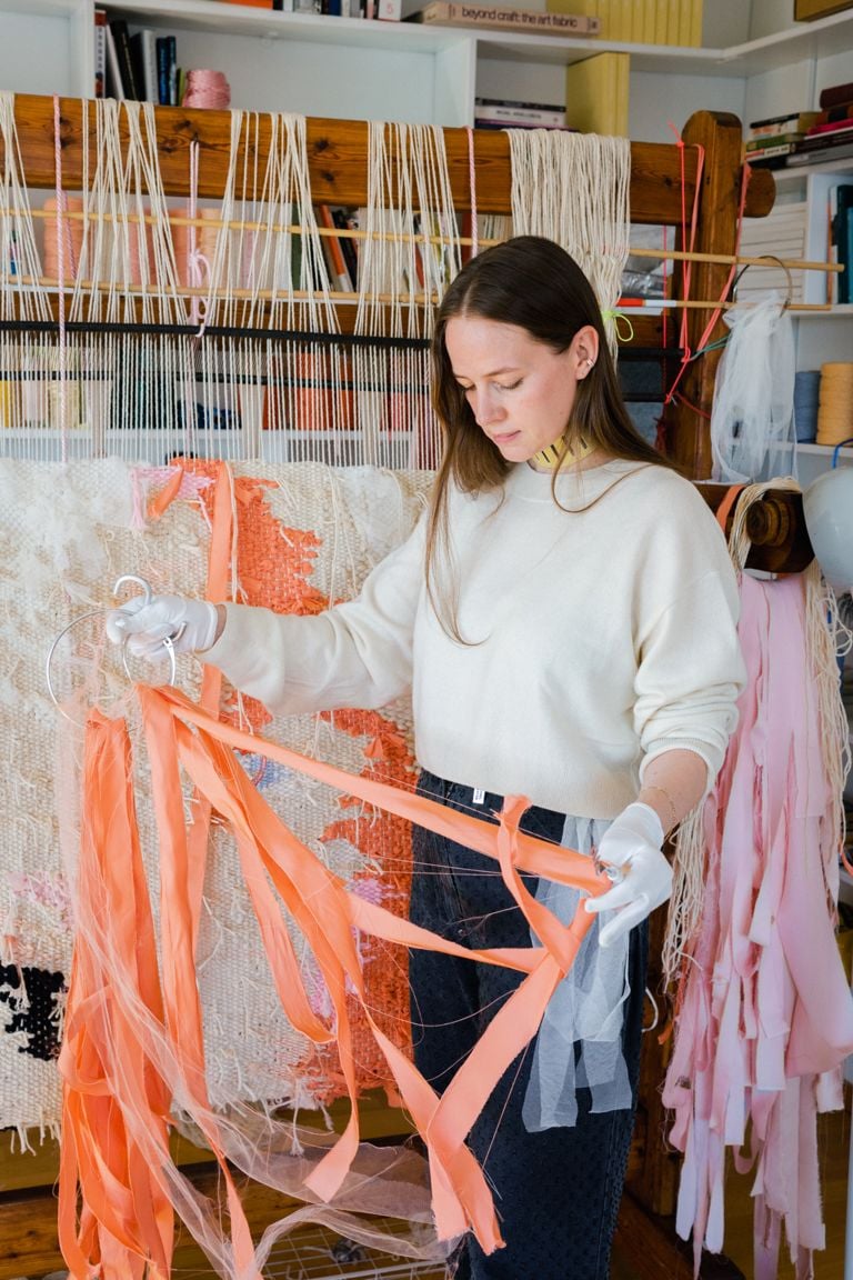 Ann Cathrin November Høibo in art studio holding pink fabric