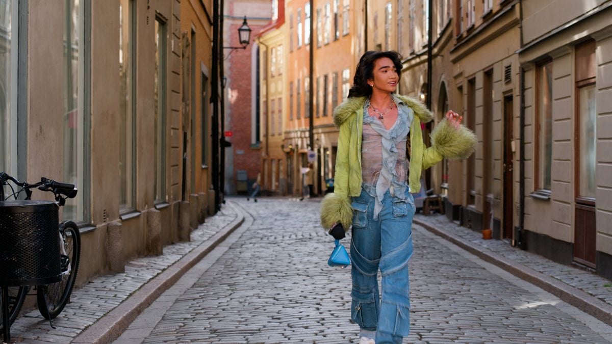 In this Bretman Rock style photo, Bretman Rock wears a blue sheer blouse, blue pants and green cardigan