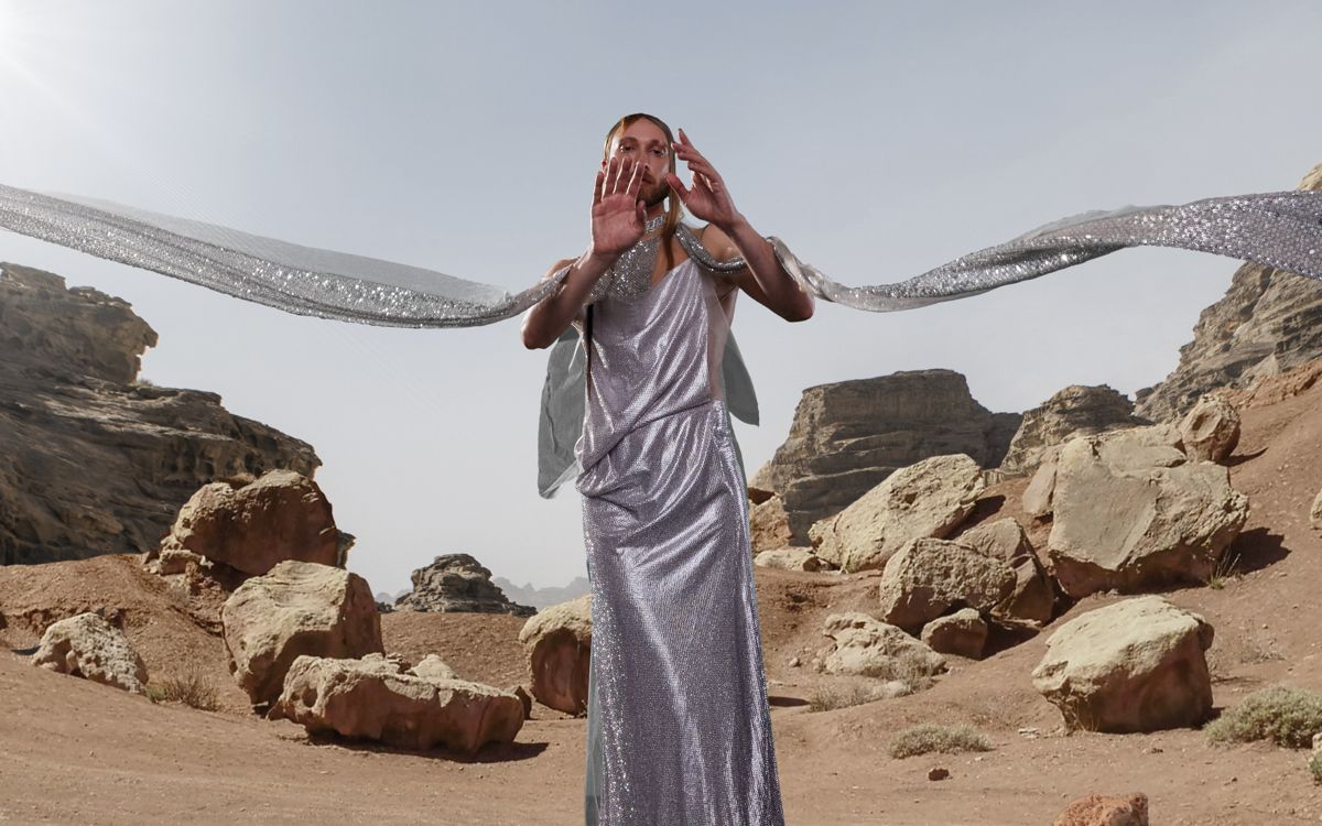 Myles Sexton poses in a silver dress and scarf