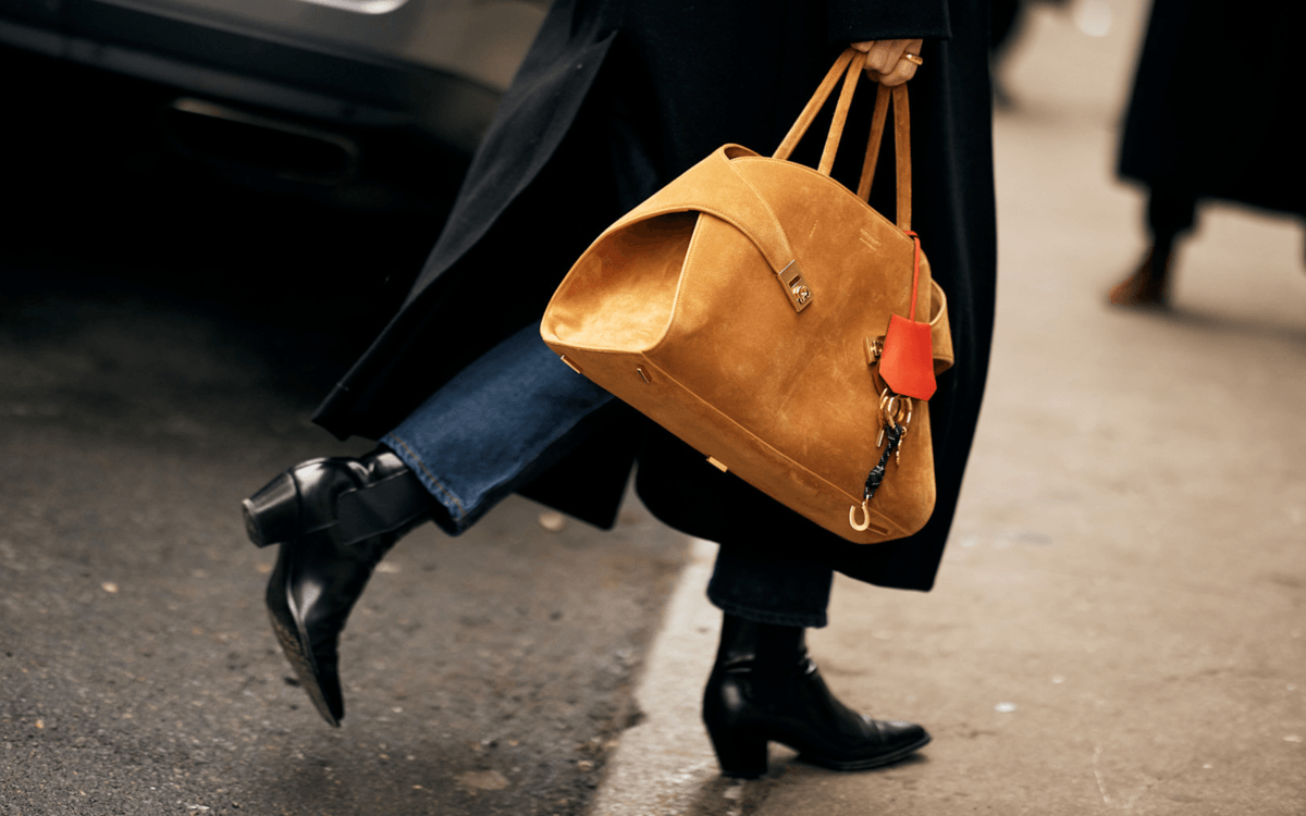 What makes a bag iconic? A person walking with their Ferragamo Hug Bag