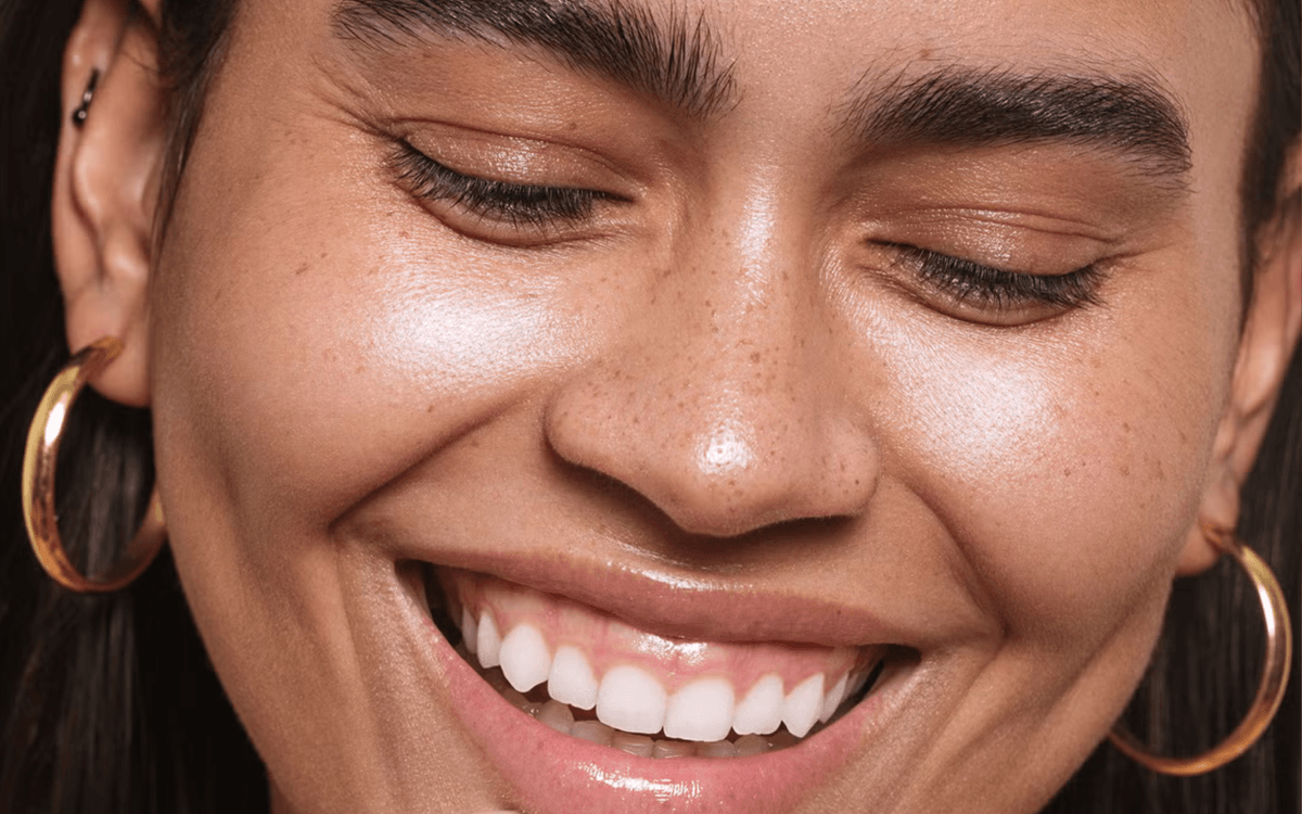 How to get butter skin, glowy vs greasy skin: A model with glowy skin smiles