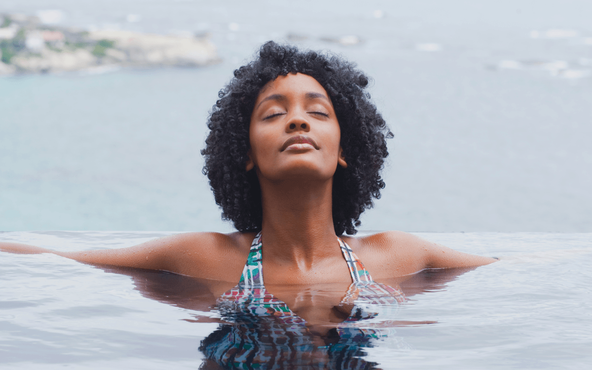 how to protect hair from chlorine, UV hair protection: A woman relaxes in a pool