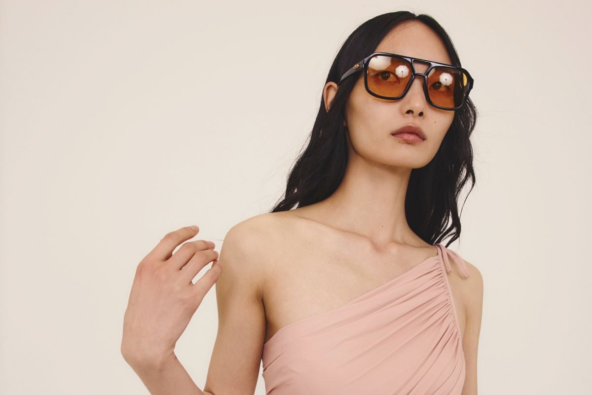 bright swimwear, swimsuit women: A woman in a one-piece swimsuit and sunglasses