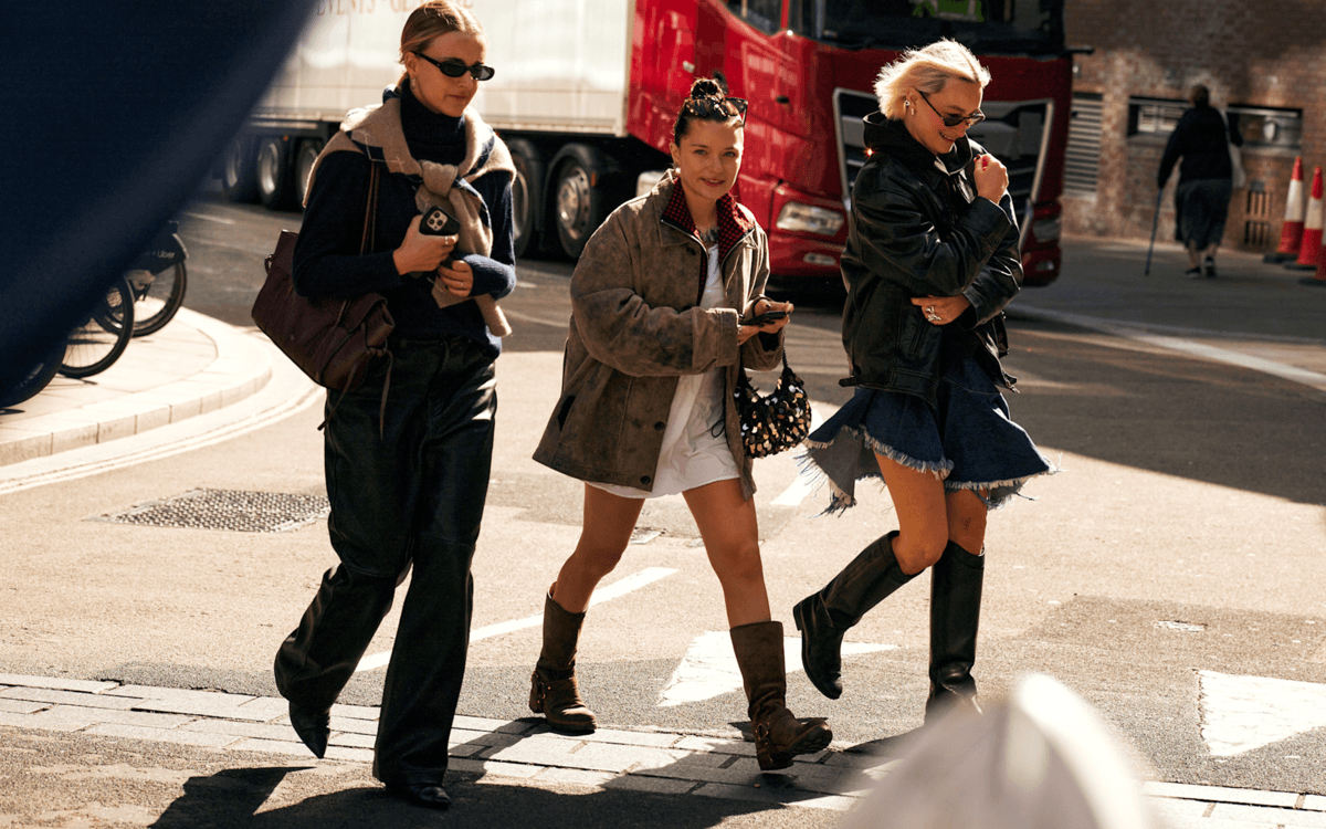 A group of women wearing boots walk down the street