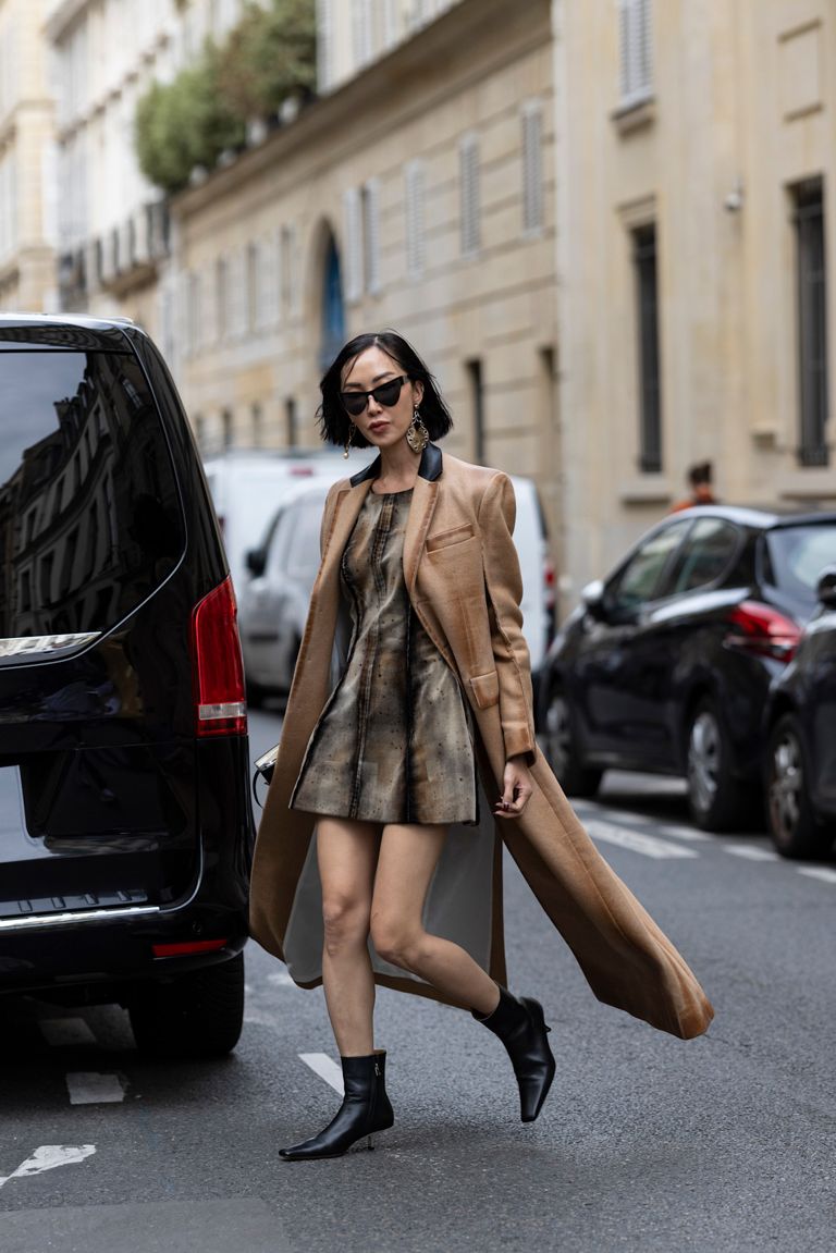 A woman wearing black ankle boots walks