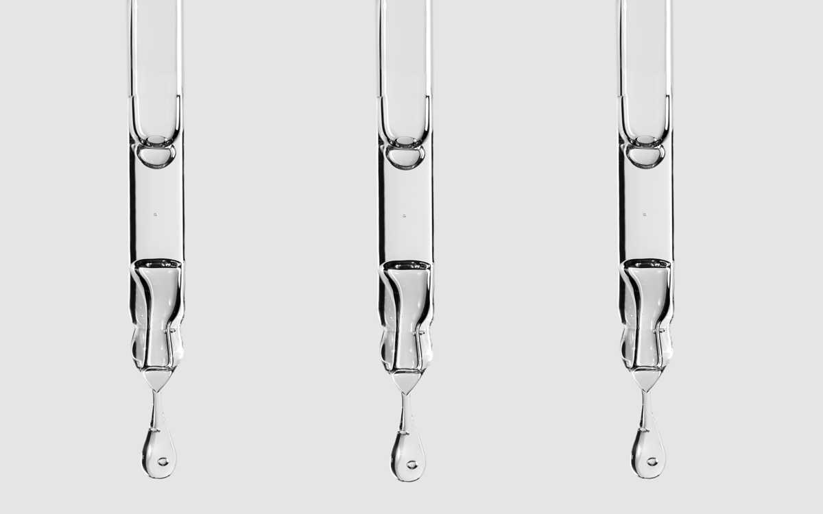Stem cell beauty, PRP, exosome: Close-up drop of cosmetic liquid falling from pipette with Face Serum or Essential Oil with Oxygen Aqua Bubbles on a grey color background.