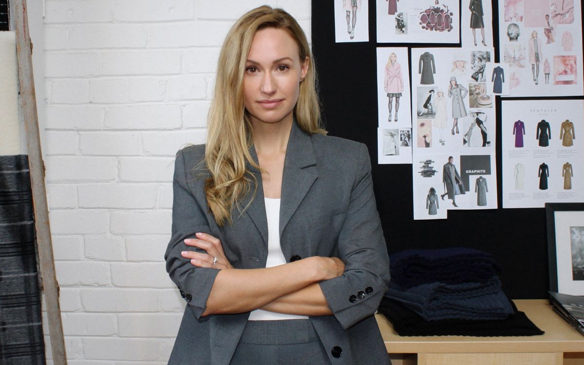 Sentaler founder poses in front of designs