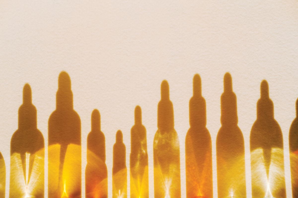 Shadows of serum bottles against a light tan background