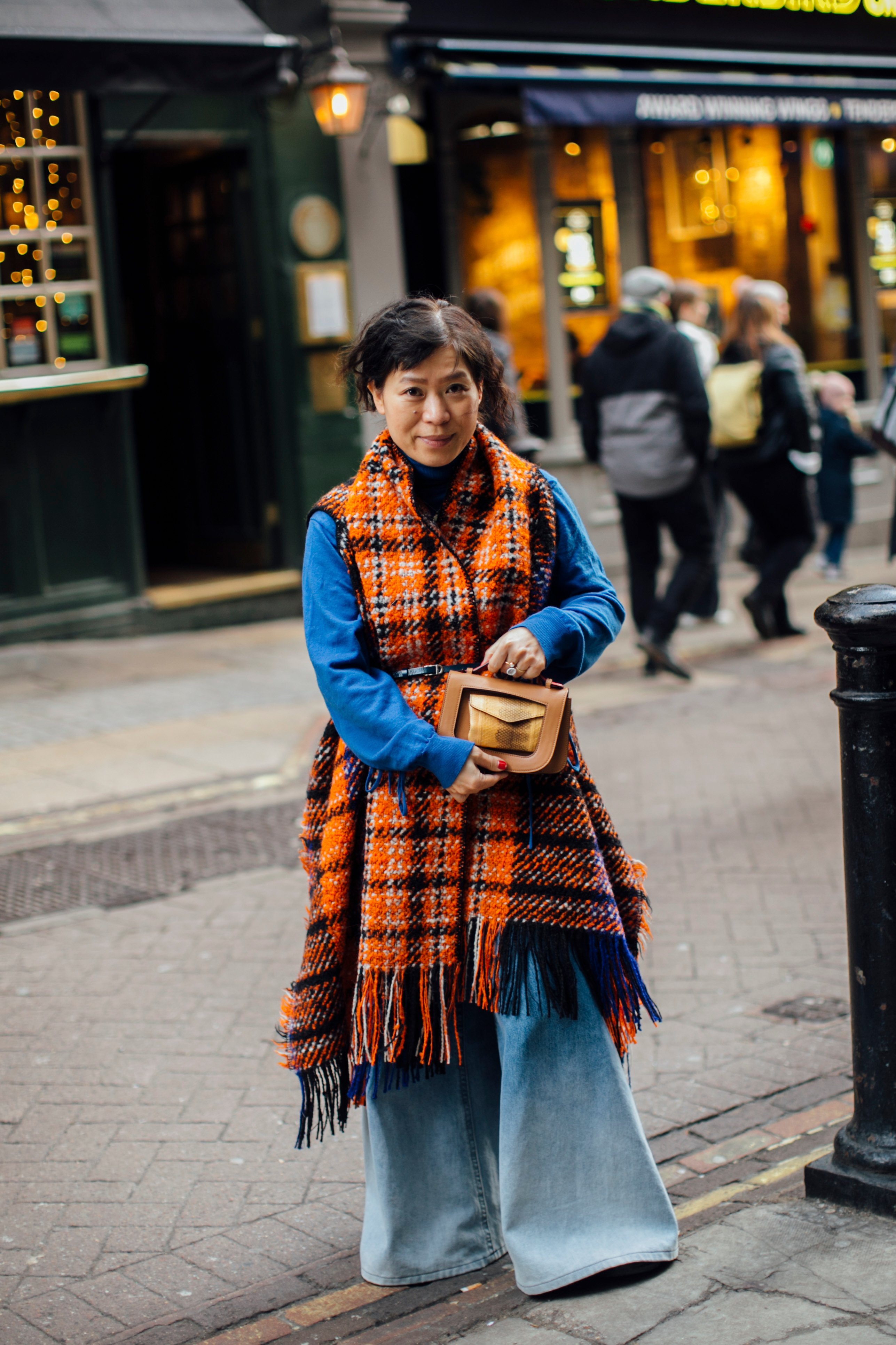 woman with blue sweater and plaid vest