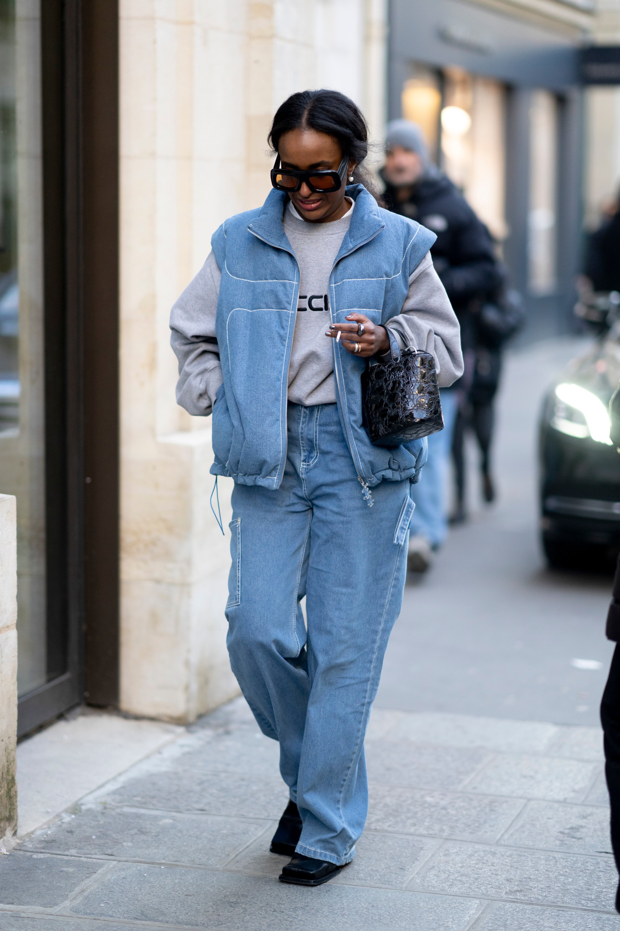 blue jean vest and jeans with grey sweater and sunglasses