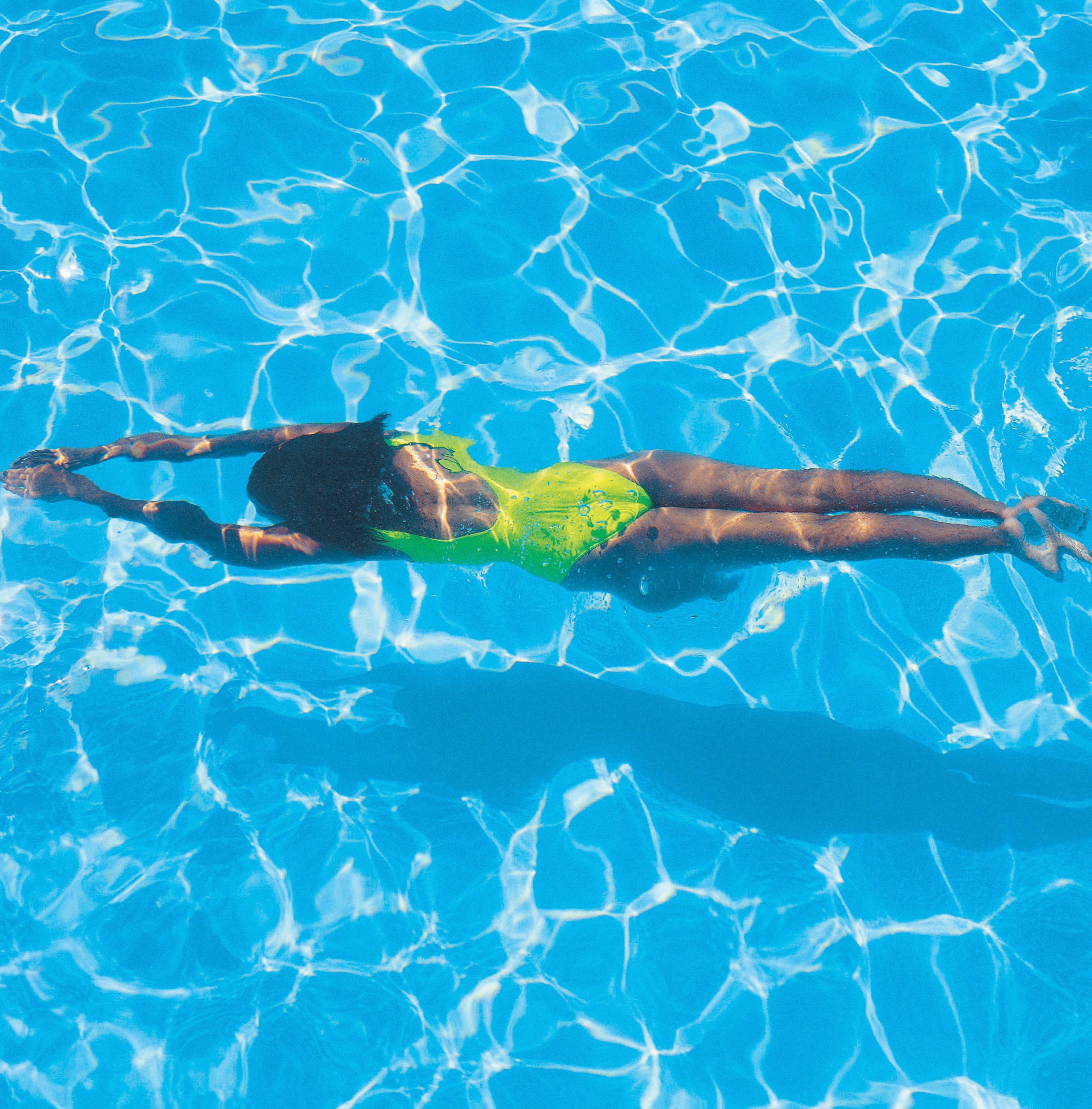 how to protect hair from chlorine, UV hair protection: A woman swims in a pool